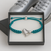 Turquoise skate bracelet resting on figure skates, ready for gifting