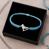 Blue ice skate charm bracelet presented in jewelry box on textured background