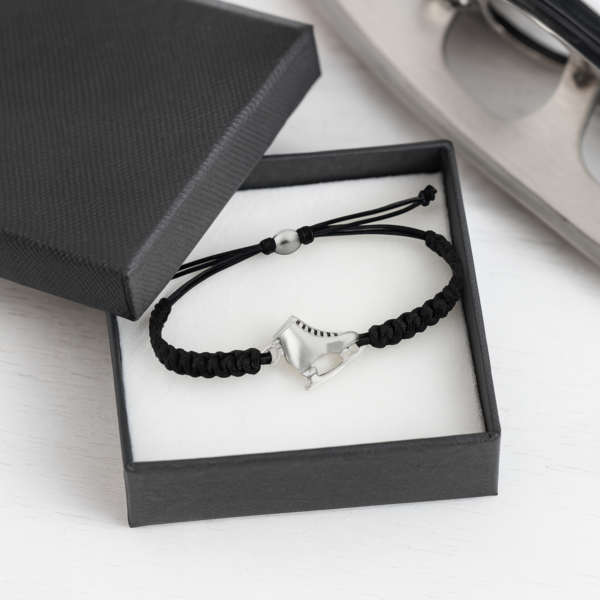 Ice skate bracelet in black displayed in a gift box, perfect for skaters