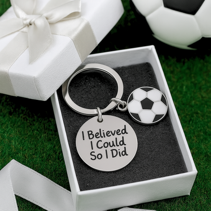Keychain placed on artificial turf with “I Believed I Could” charm, great for soccer gifts