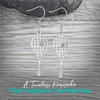 Gold and silver tennis racket earrings displayed on wood surface"