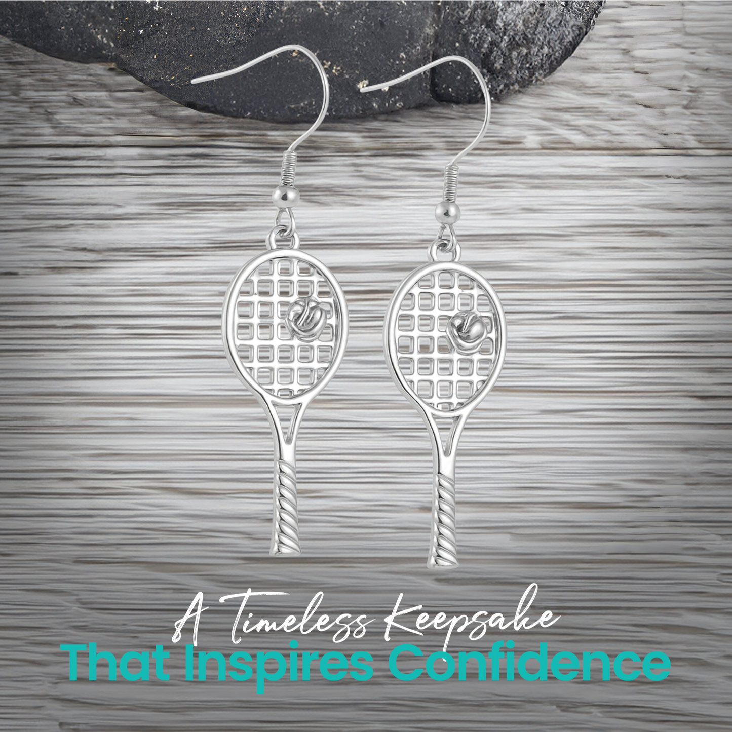 Gold and silver tennis racket earrings displayed on wood surface"