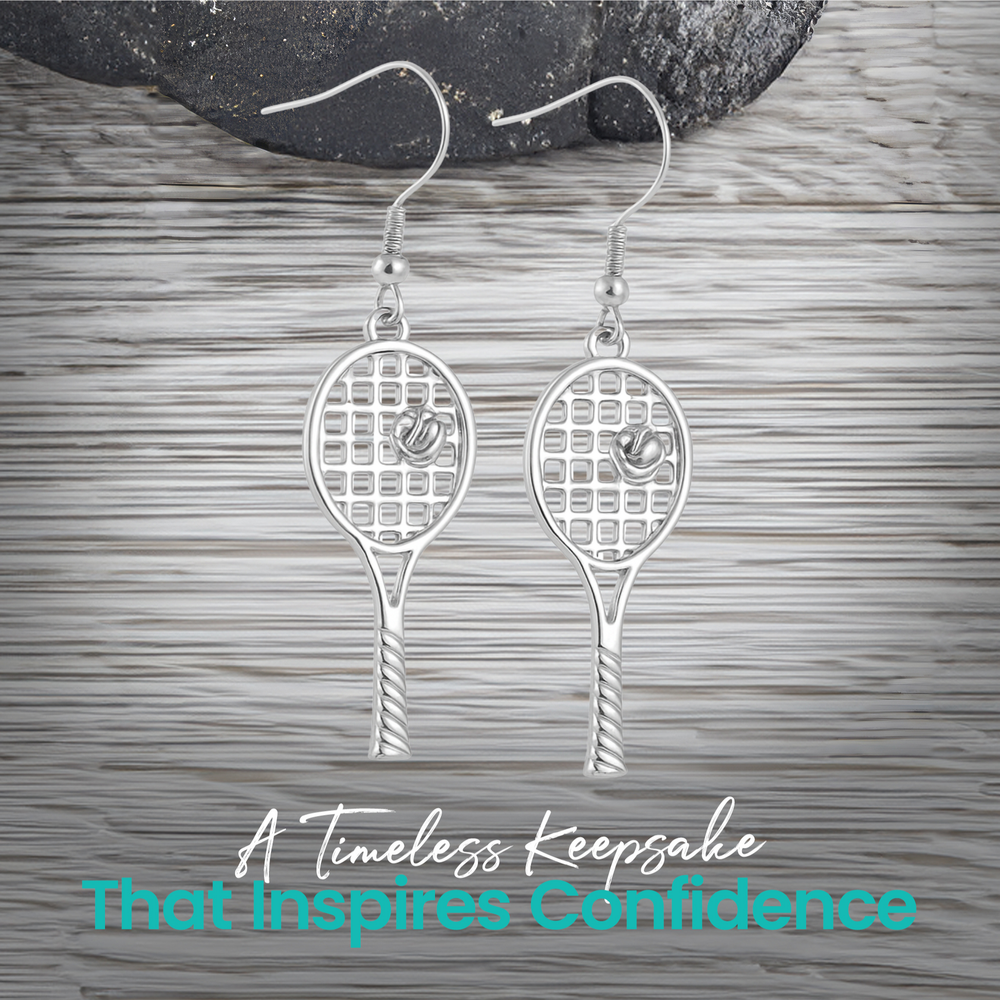 Gold and silver tennis racket earrings displayed on wood surface"
