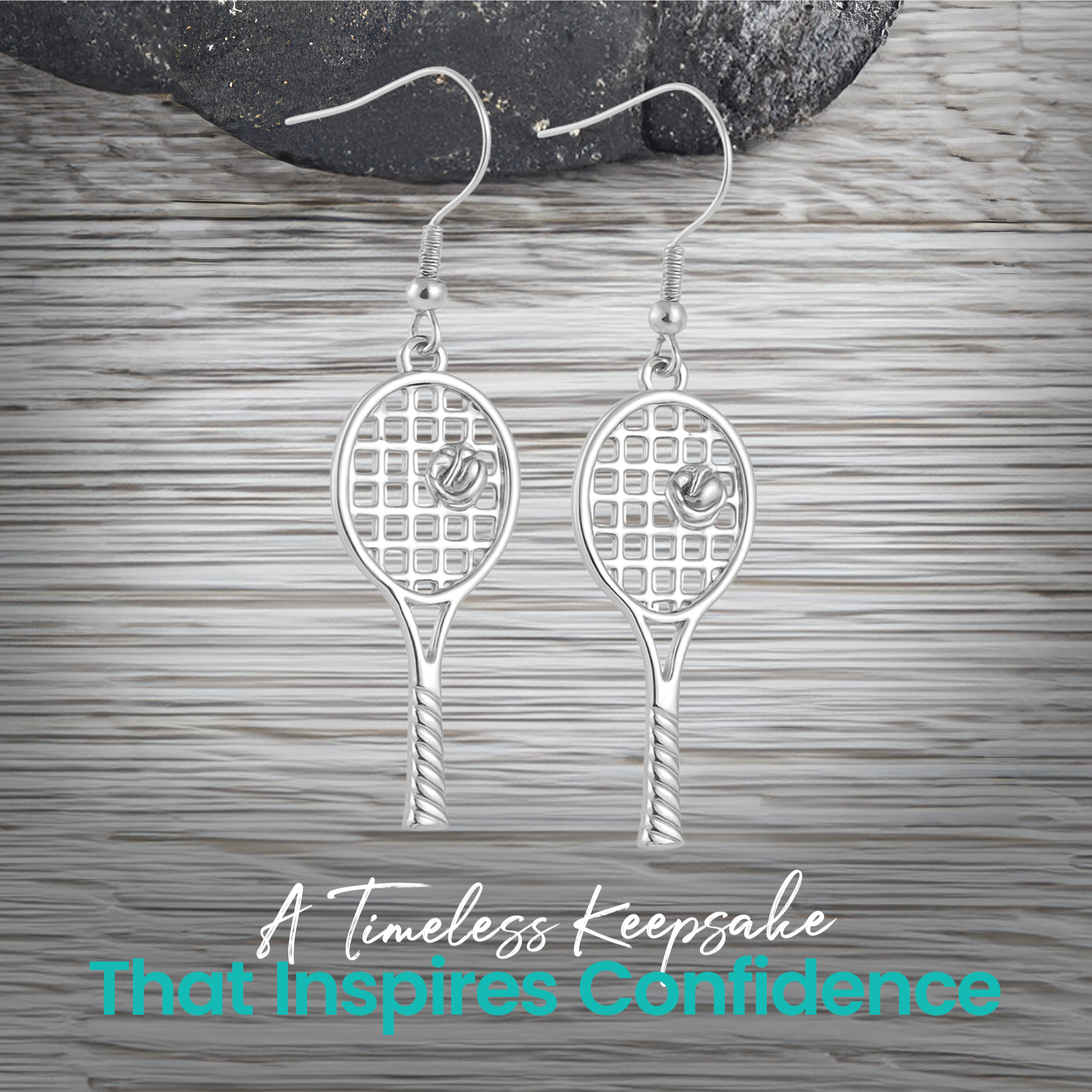 Gold and silver tennis racket earrings displayed on wood surface"