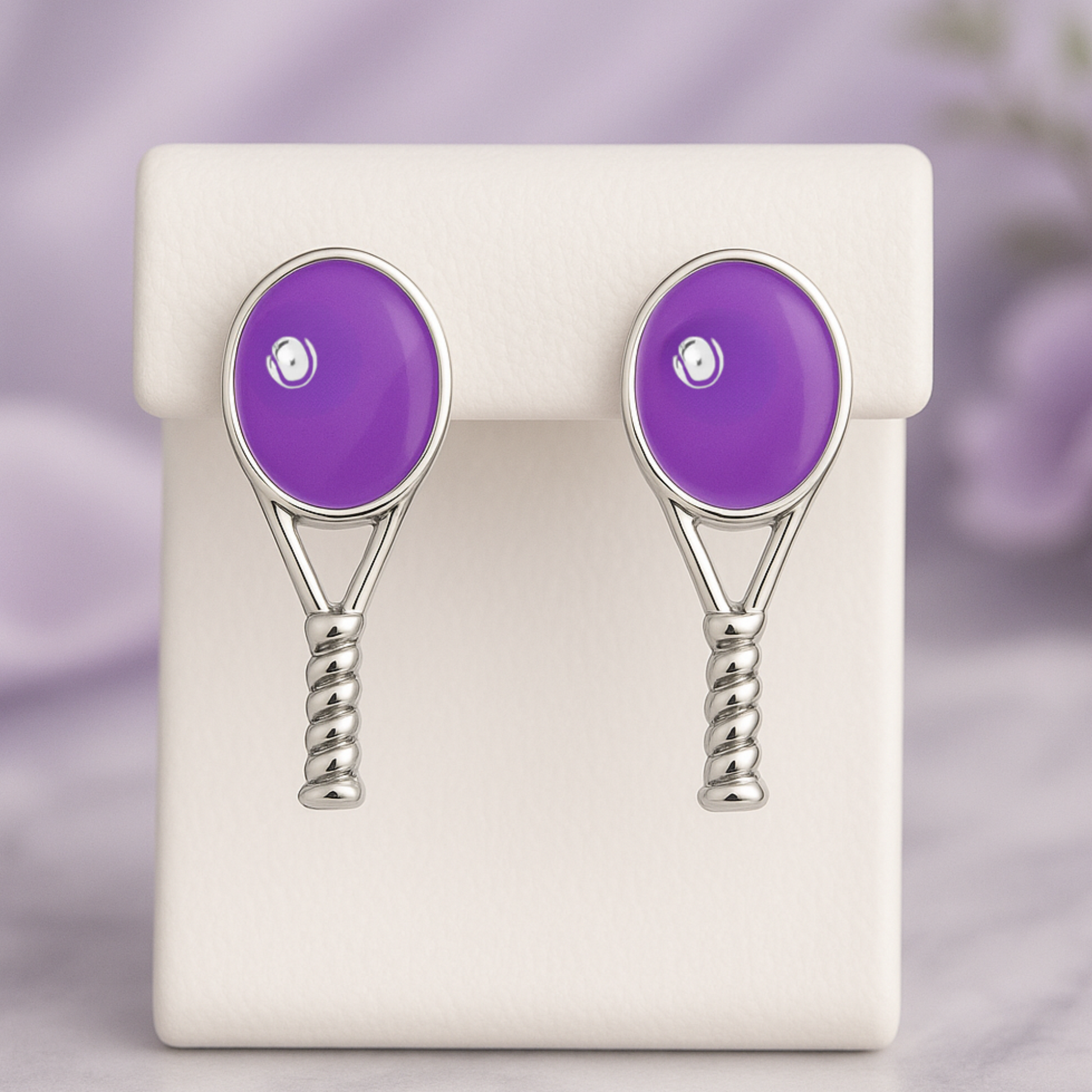Purple tennis racquet stud earrings displayed on jewelry card