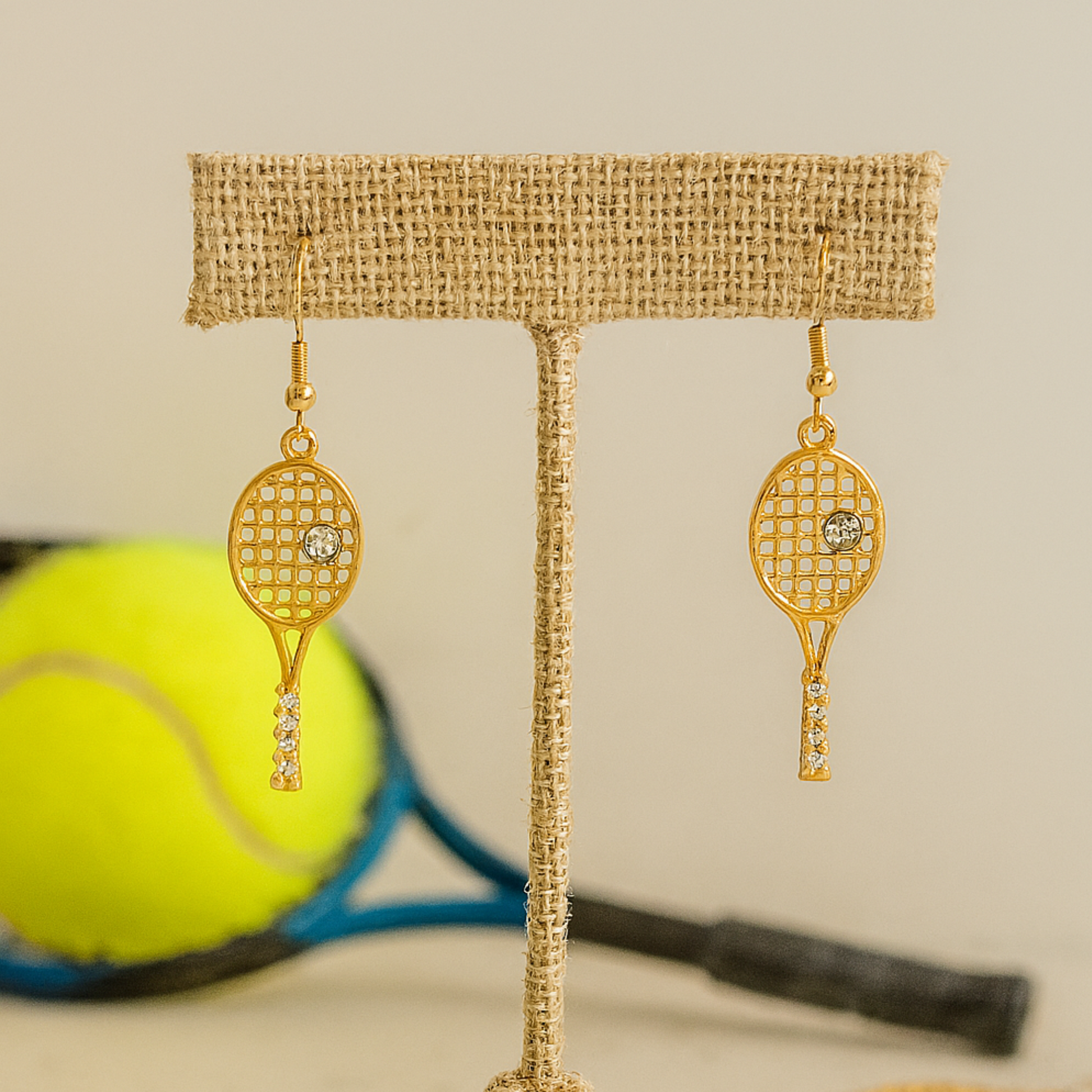 Gold tennis racket earrings with rhinestone detail on fishhook ear wires