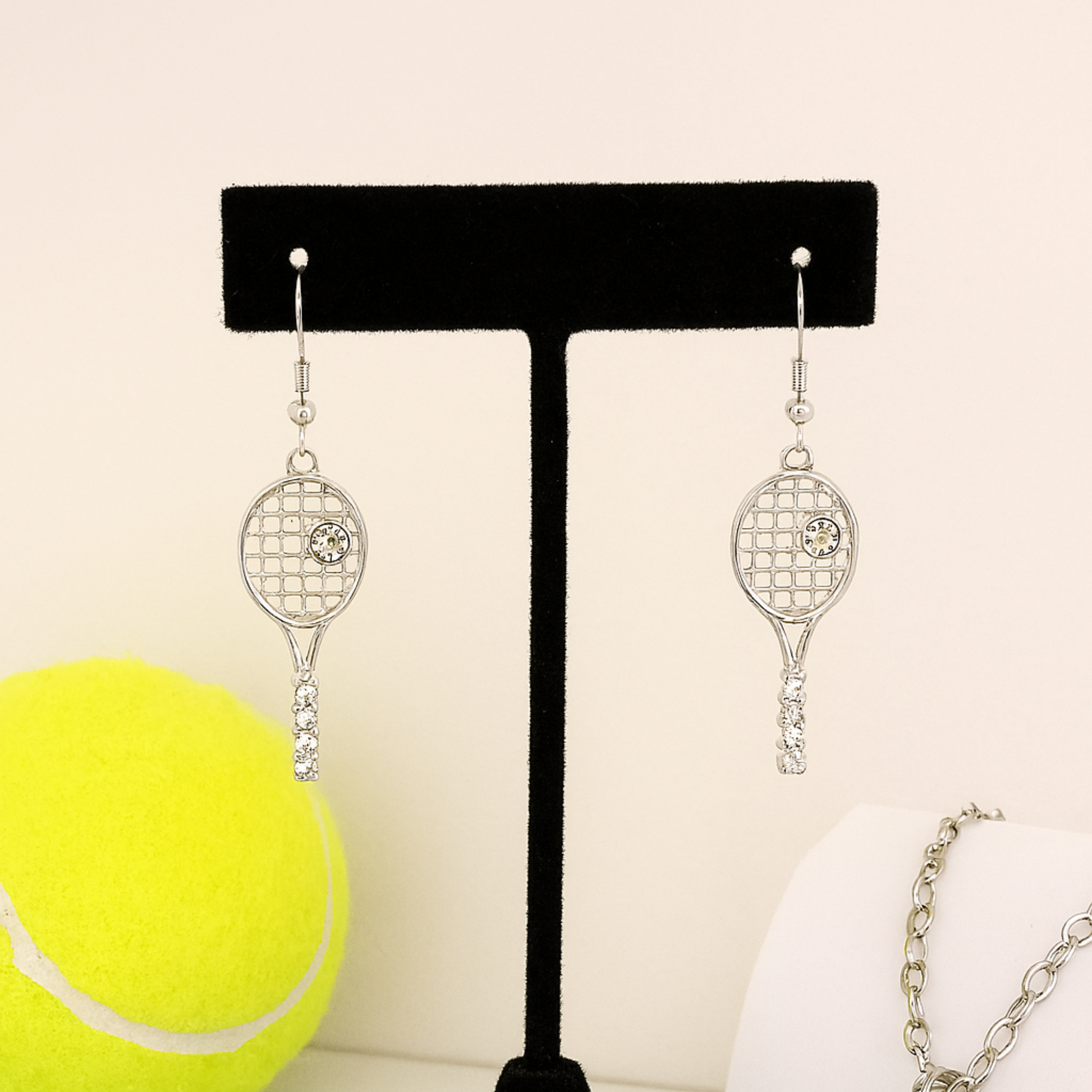 Silver tennis racket dangle earrings with rhinestone accents for sports fans