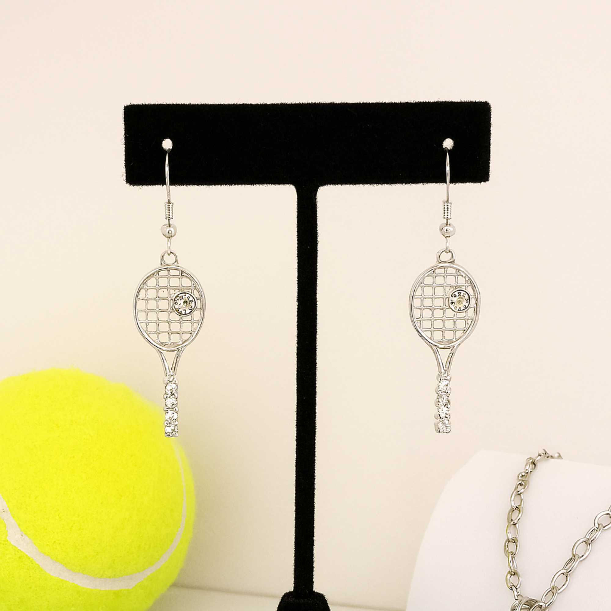 Silver tennis racket dangle earrings with rhinestone accents for sports fans