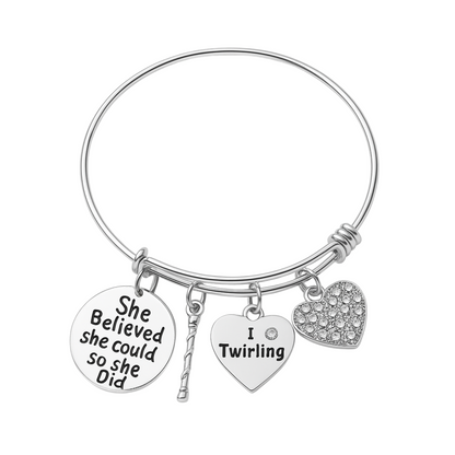 Silver adjustable bangle bracelet with twirling-themed charms including "She Believed She Could So She Did" and heart shapes