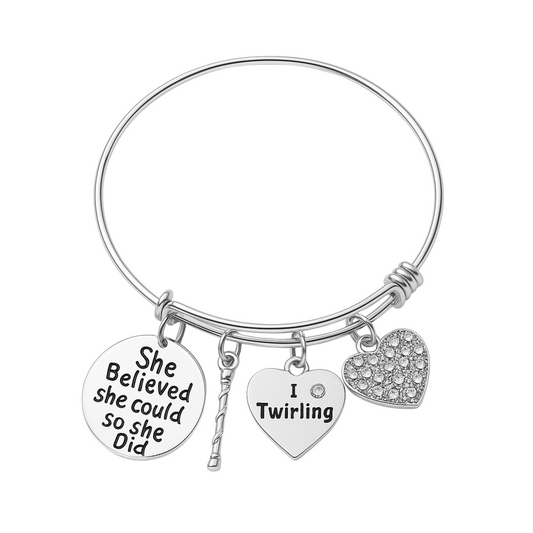 Silver adjustable bangle bracelet with twirling-themed charms including "She Believed She Could So She Did" and heart shapes