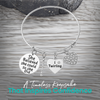 Silver twirling bangle bracelet photographed on wood background with message "I twirl therefore I sparkle"