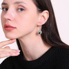 Woman wearing silver volleyball dangle earrings with french hook design