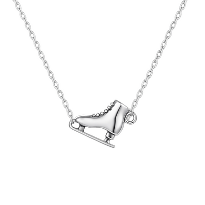 Close-up of ice skate necklace pendant on silver chain, displayed on white background