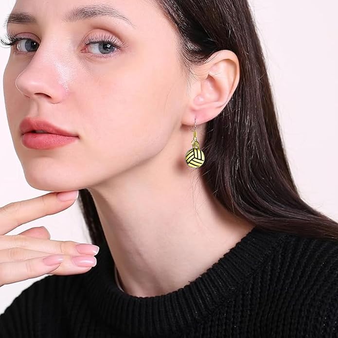 Dainty gold volleyball earrings worn by a woman, showcasing premium quality and timeless design.