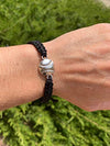 Black softball rope bracelet worn on wrist with silver baseball charm, ideal for girls softball gifts and team spirit.