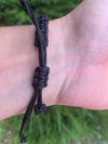 Black softball rope bracelet worn on wrist, ideal accessory for girls softball players and fans.