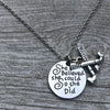 Silver field hockey necklace with engraved inspirational pendant displayed on gray fabric