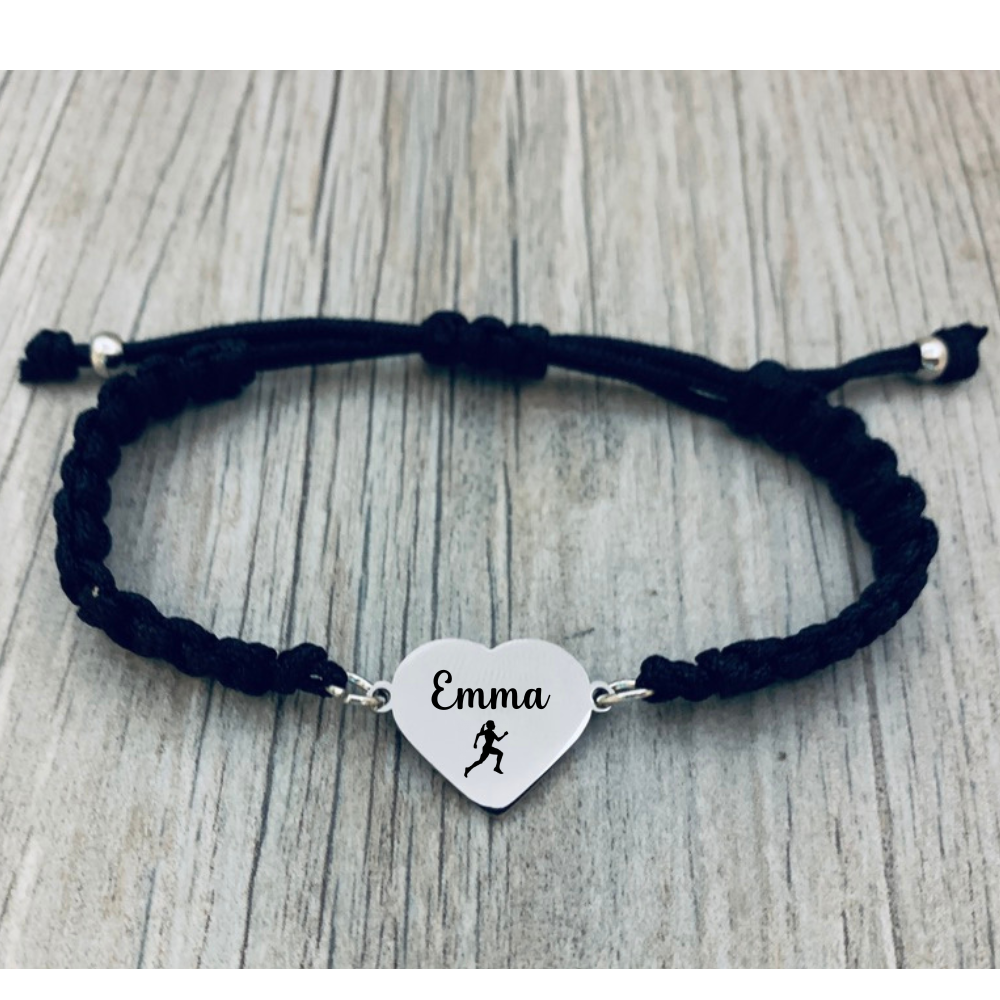 Lifestyle photo of navy rope bracelet with engraved running charm on wood surface