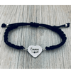 Black braided bracelet with trumpet charm displayed on wood background