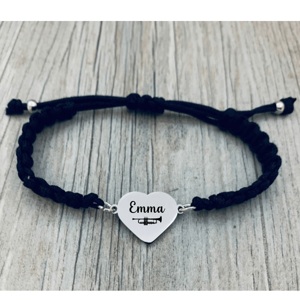 Black braided bracelet with trumpet charm displayed on wood background
