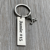 Custom engraved name bar field hockey keychain on gray wood surface