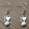 Silver volleyball heart earrings displayed on textured gray surface