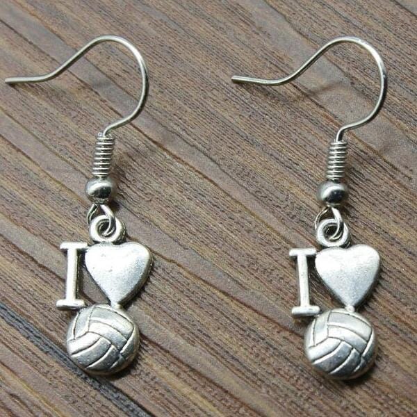 Silver volleyball heart earrings displayed on textured gray surface