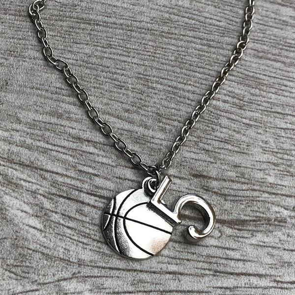  Basketball charm necklace with number 5 laid flat on rustic wooden surface