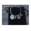 Swim team gift bracelet with inspirational quote charm and swimmer charms on black display