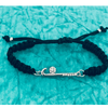 Field hockey bracelet with silver stick charm displayed on turquoise fabric background