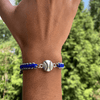 Multi colored softball rope bracelet with silver softball charm on wrist, perfect for girls softball jewelry and team gifts.