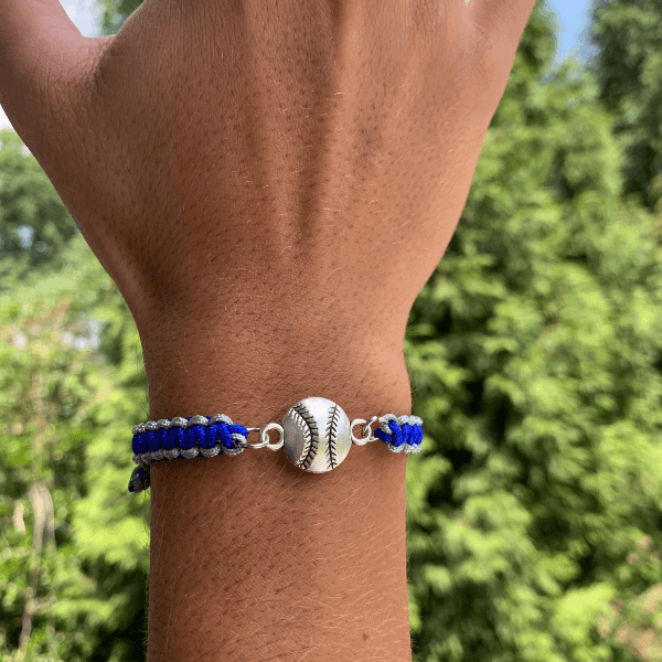 Multi colored softball rope bracelet with silver softball charm on wrist, perfect for girls softball jewelry and team gifts.